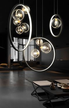 three circular lights hanging from the ceiling in a dark room with black walls and flooring