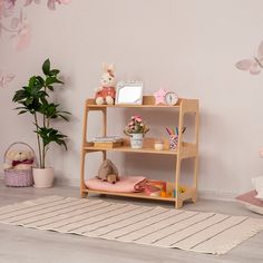 a wooden shelf with stuffed animals on it in a girls'room next to a potted plant