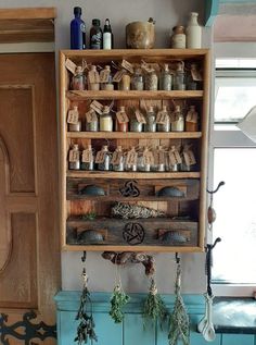 an old wooden shelf filled with lots of spices and herbs on top of a blue cabinet