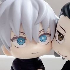 two anime dolls one with blue eyes and the other with white hair, are sitting next to each other