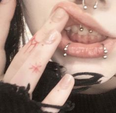 a close up of a person with fake teeth and piercings