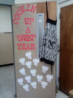 a bulletin board with cooking up a great year written on it and oven mitts