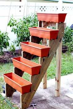 some planters are on the side of a wooden ladder in front of a house