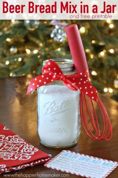 a mason jar filled with beer bread mix in a jar next to a christmas tree