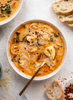 two bowls of soup with bread on the side