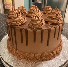 a chocolate cake sitting on top of a white plate covered in frosted icing