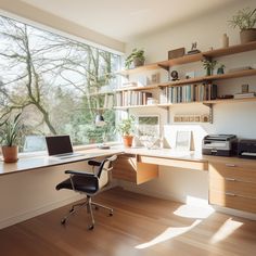 a desk with a laptop on it in front of a large window overlooking the woods