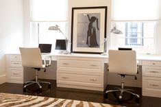 a white desk with two chairs and a poster on the wall