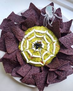 a white plate topped with tortilla chips and a spider on top of it