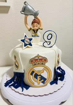 a birthday cake with a figurine holding a trophy