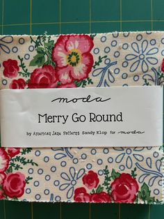 a piece of fabric with flowers on it and a sign that says more merry go round