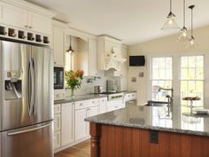 a large kitchen with white cabinets and stainless steel appliances, along with marble counter tops