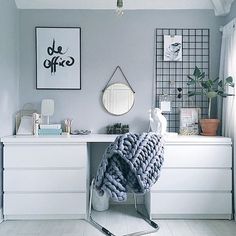 a white desk with a mirror and pictures on the wall