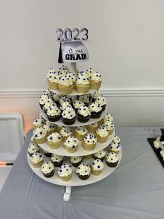 cupcakes are stacked on top of each other in front of a graduation cake