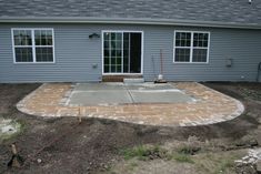 a patio being built in front of a house with no grass or rocks on the ground