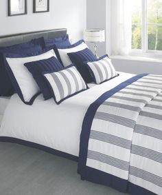 a bed with blue and white comforters in a bedroom