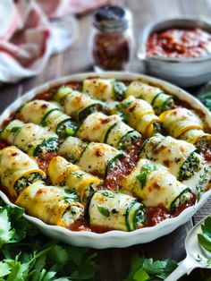 a casserole dish filled with zucchini and spinach covered in sauce