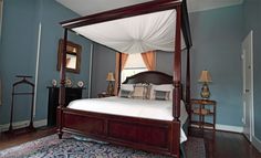 a canopy bed in a bedroom with blue walls