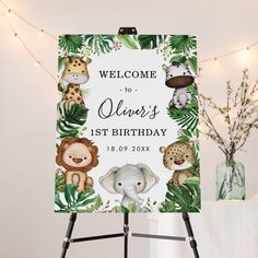 a welcome sign with jungle animals and palm leaves in front of a white background that says, welcome to oliver's 1st birthday