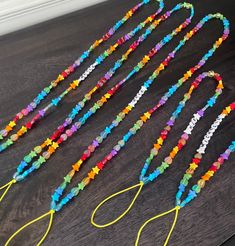 several colorful beads are lined up on a table next to some scissors and stringing