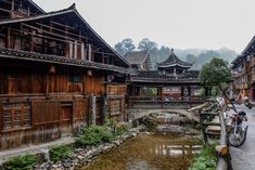 an old village with wooden buildings and a river running through it