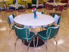 an empty table and chairs in a large room with tables set up on the floor