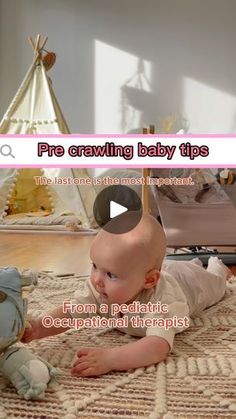 a baby laying on top of a rug next to a stuffed animal toy in front of a teepee