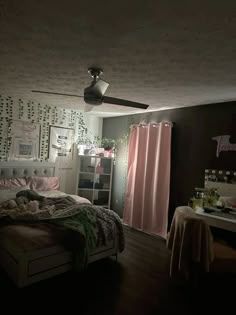 a bed room with a neatly made bed next to a window and a ceiling fan