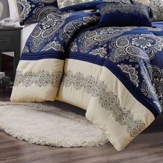 a blue and white comforter set with paisley print on the bed in a bedroom