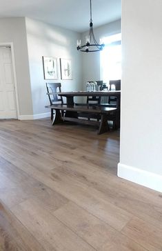 an empty dining room with wood floors and white walls