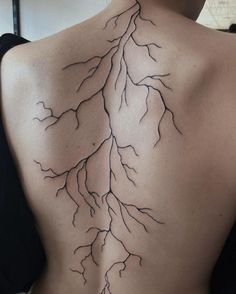 the back of a woman's upper body with branches on her left shoulder and lower back