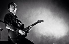 black and white photograph of a man playing an electric guitar