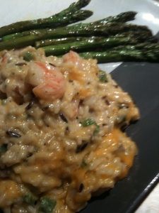 a close up of a plate of food with asparagus and shrimp on it