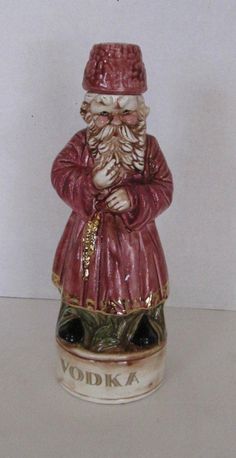 a ceramic figurine of a man with a beard and mustache wearing a red hat