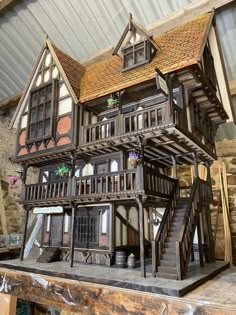 a wooden model of a house on display in a building that has been built into the ground