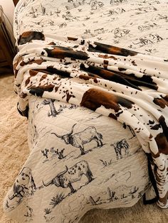 a cow print bed spread on top of a bed