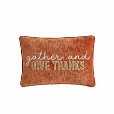 an orange pillow with the words gather and give thanks written on it in gold foil