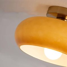 a close up of a light fixture on a white wall with a gold colored finish