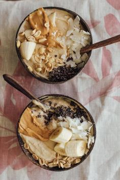 two bowls filled with oatmeal and bananas on top of a floral table cloth