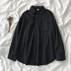 This shirt is perfect for those who are looking for a new shirt for a good price. It is fashionable, stylish, and it will look great on anyone who wears it. Black Solid Color Button-up Shirt, Trendy Black Tops With Pockets, Black Button-up Blouse, Long Sleeve School Tops With Button Closure, Long Sleeve Shirt With Button Closure For School, Long Sleeve Tops With Button Closure For School, Black Solid Color Shirt For Spring, Trendy Cotton Blouse With Buttons, Trendy Cotton Blouse With Button Closure