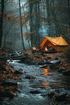 a tent set up in the woods next to a stream