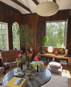 a living room filled with furniture and lots of plants on top of a glass table