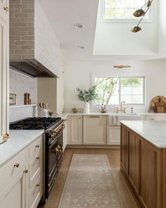 a kitchen with an oven, sink and stove top in it's center island