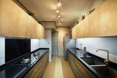 a long narrow kitchen with black counter tops