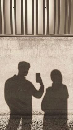 the shadow of two people standing next to each other