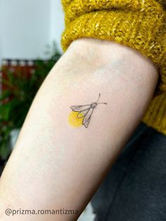 a woman's arm with a small yellow butterfly tattoo on the back of her left arm