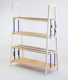 a wooden shelf with blue tape on the bottom and two shelves below it, against a white background