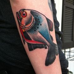 a colorful fish tattoo on the arm