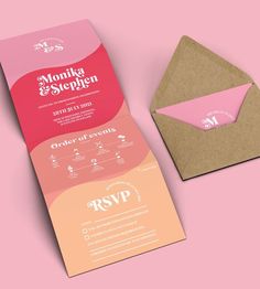 a pink and orange business card next to an envelope with the letter m on it