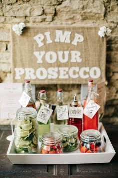 some jars filled with food sitting on top of a wooden table next to a sign